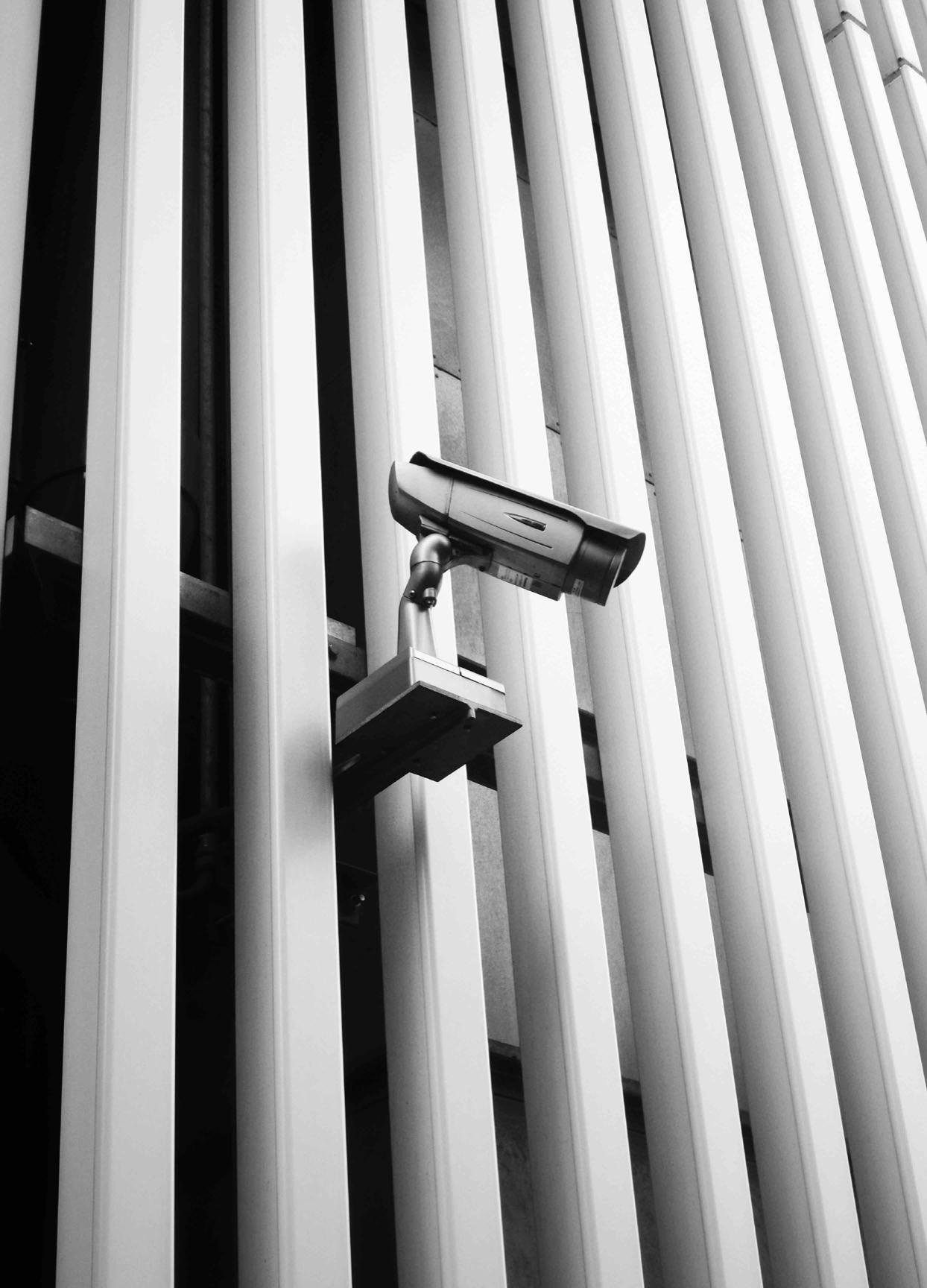 Security camera mounted to a building pointing down